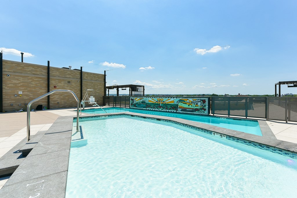 a swimming pool on the rooftop of a building with a fence
