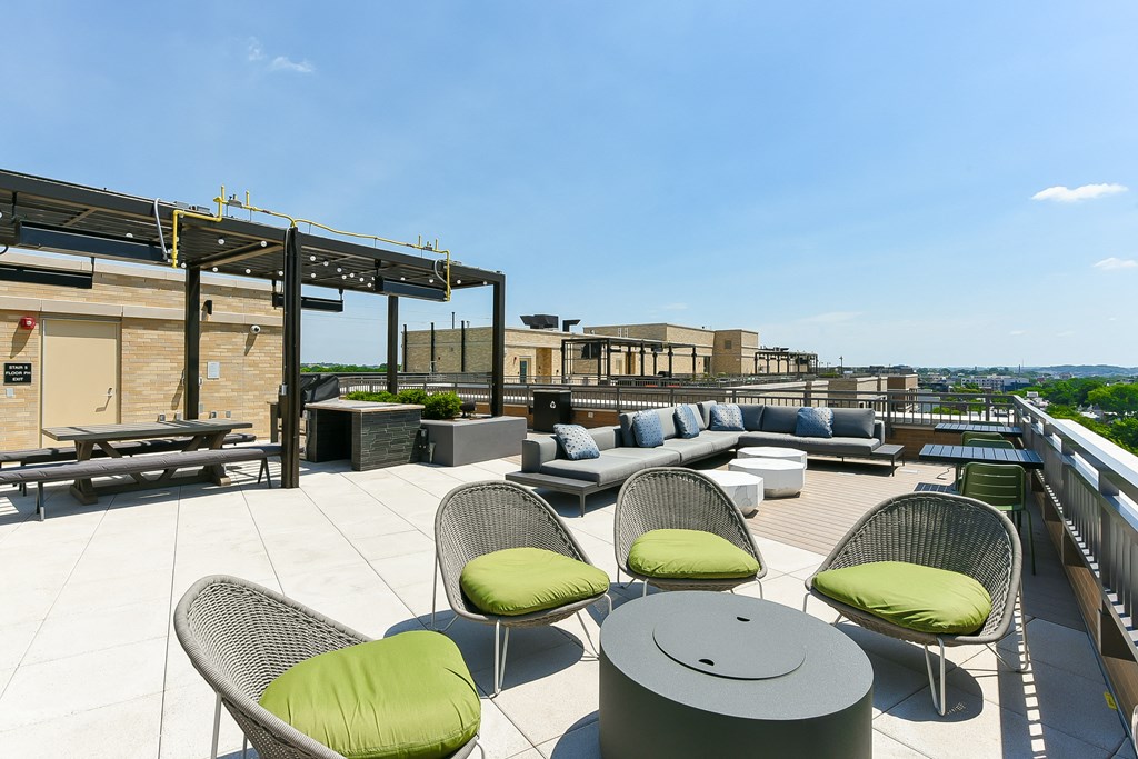 a roof top patio with furniture and a view of the city