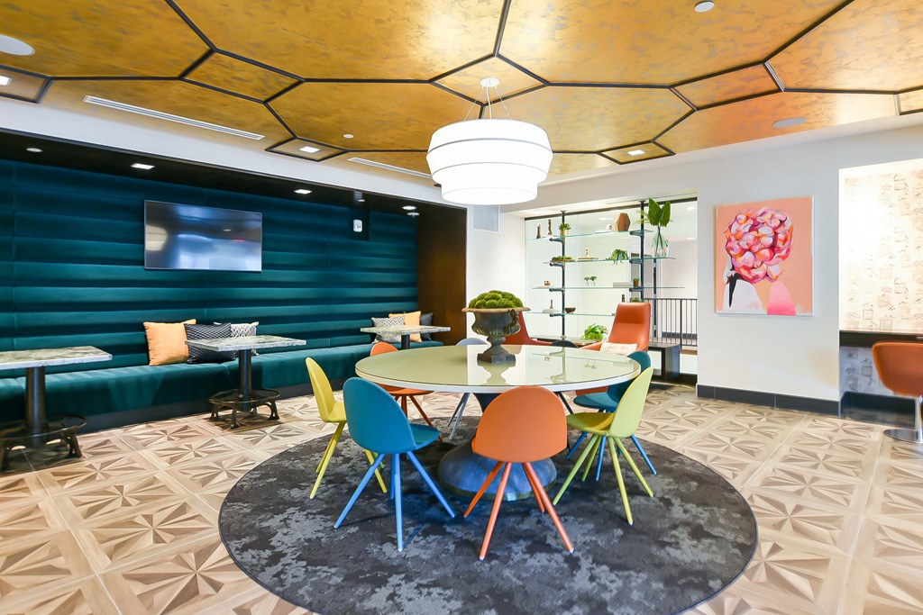 a dining room with a round table and colourful chairs