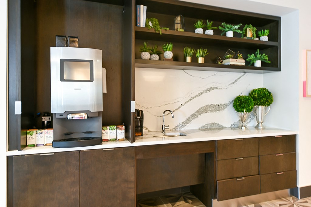 a kitchen with a coffee maker and a counter with plants