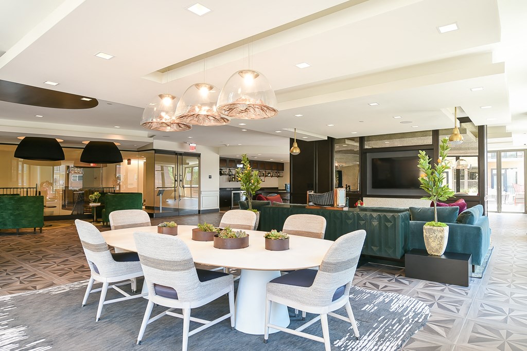 a large dining room with white chairs and a white table
