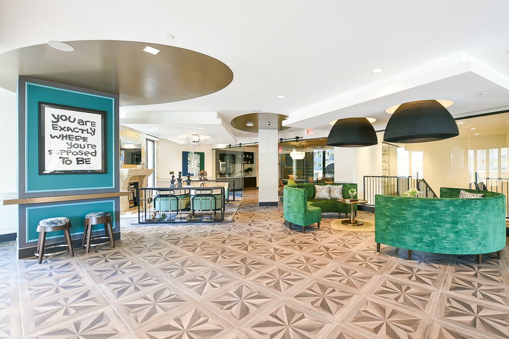 a large lobby with green chairs and a sign on the wall