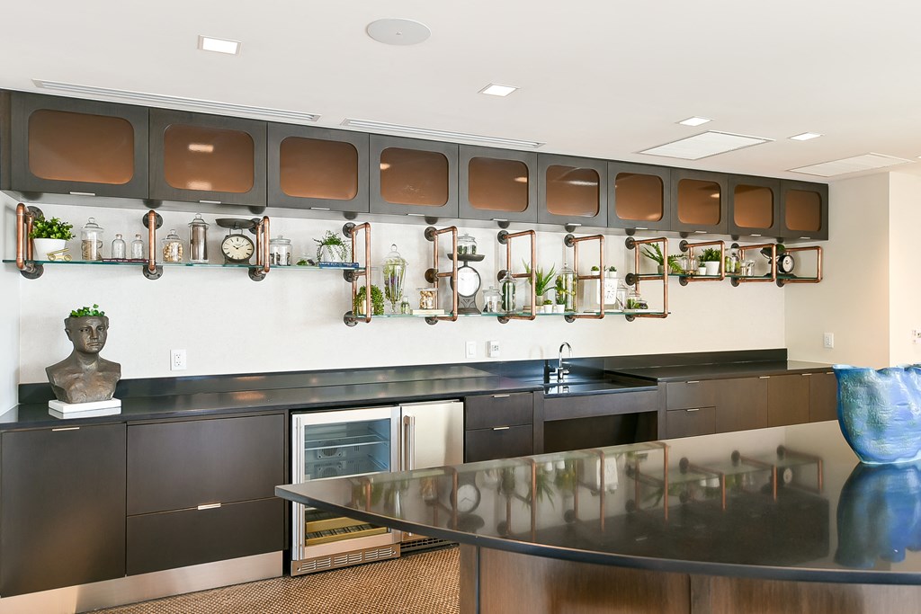 a kitchen with black counters and a counter top and a wall of pots and pans