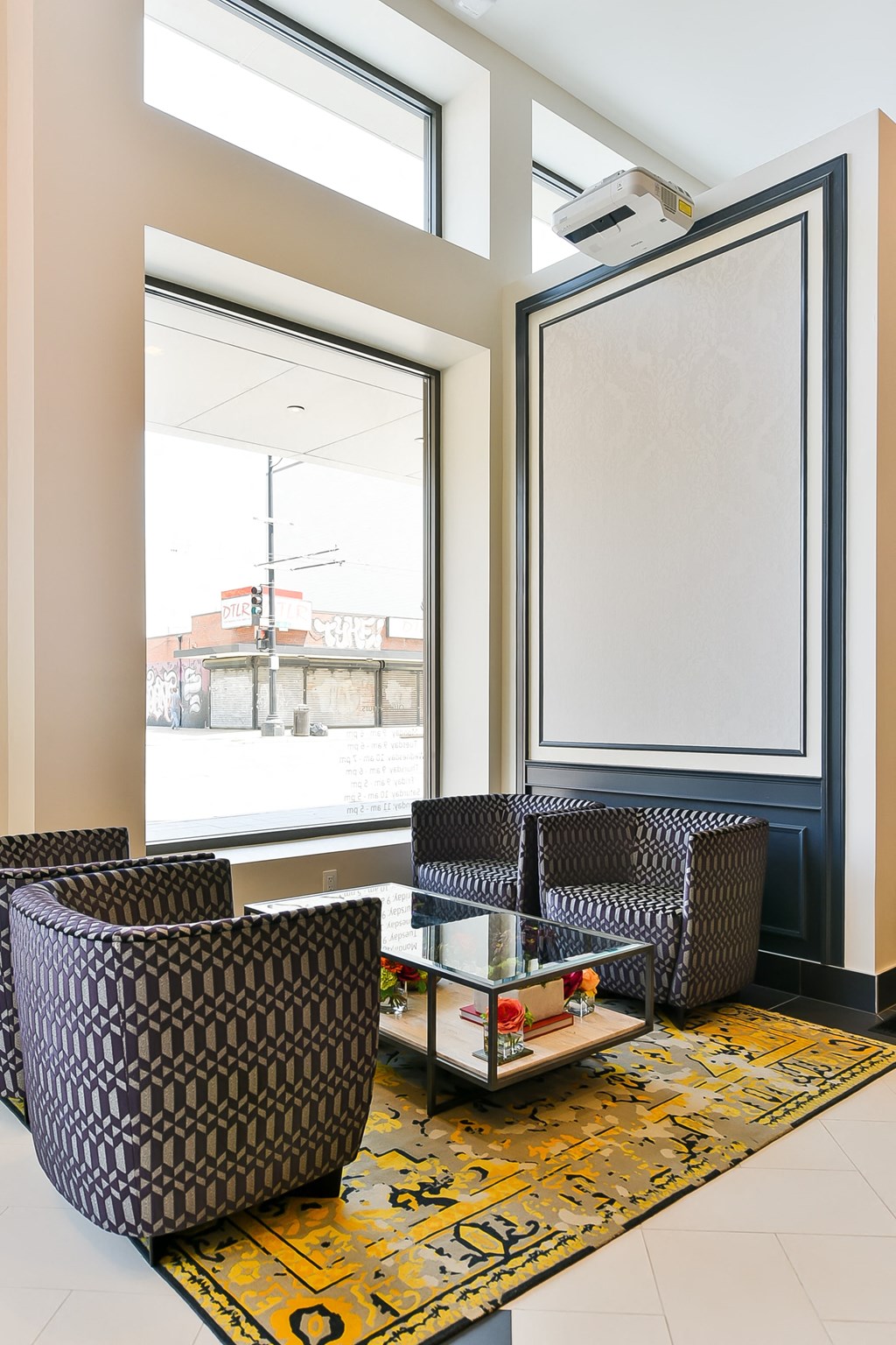 a seating area with chairs and a coffee table in front of a window