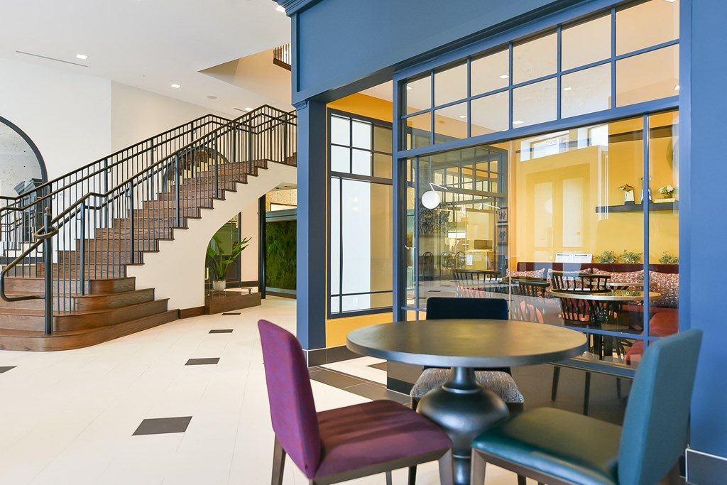 a lobby with a table and chairs and a staircase