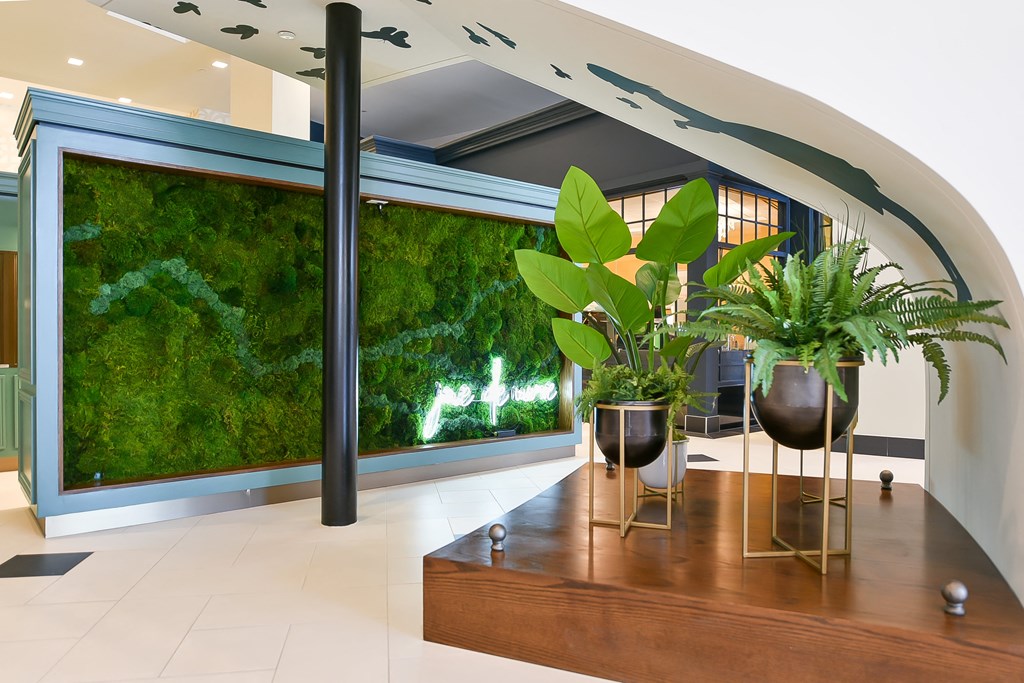 a living wall in a lobby with plants and a wooden table