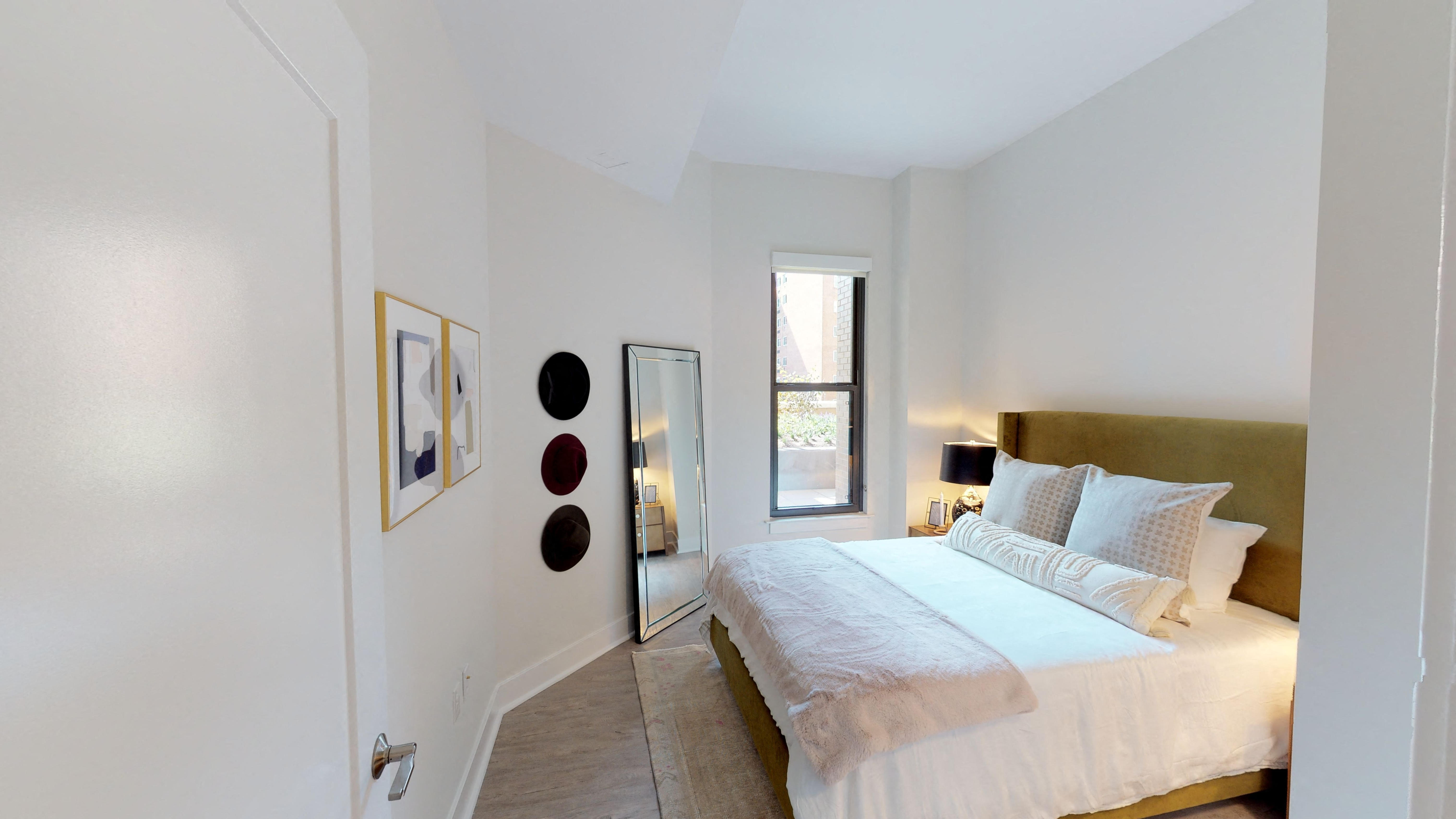 a bedroom with a bed and a mirror