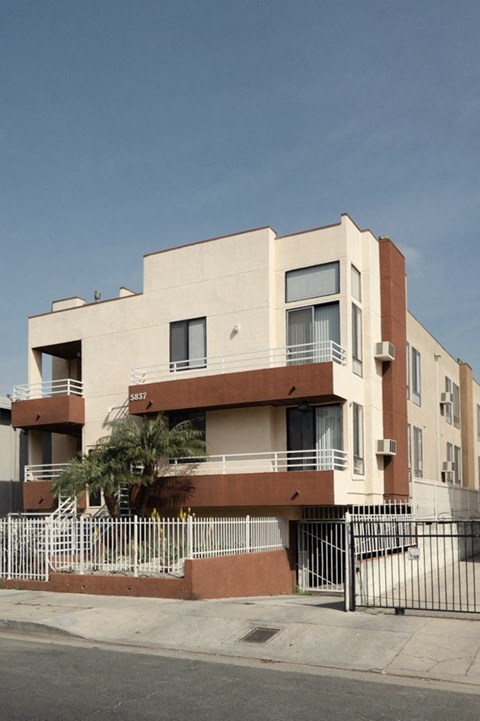 A modern building with a balcony and a gate in front.