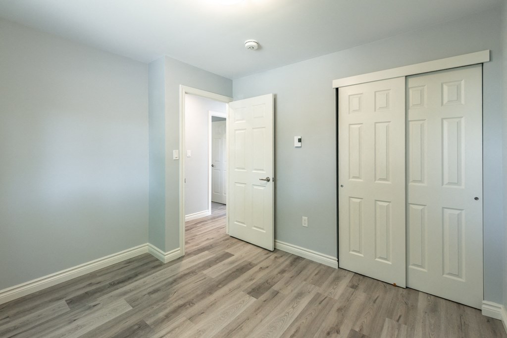 a bedroom with two closets and a door to a hallway