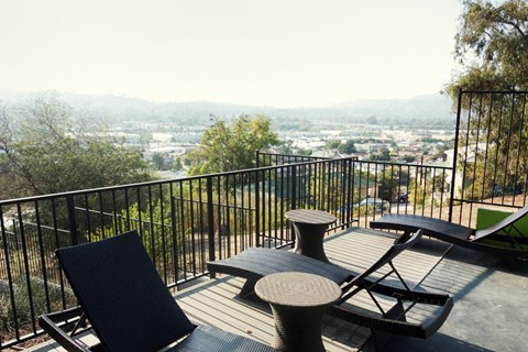 a deck with chairs and a view of the city