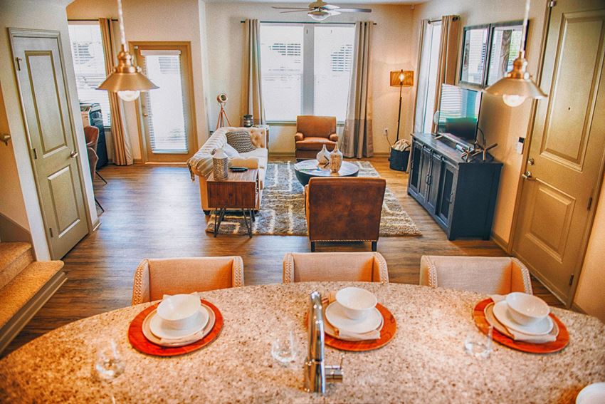 a living room and dining room with a table and chairs