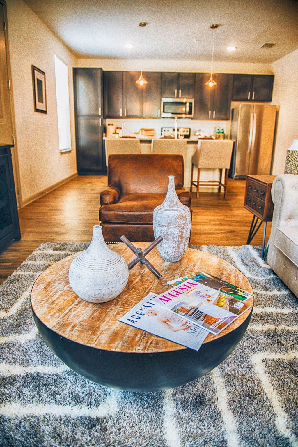 a living room with a coffee table and a kitchen in the background