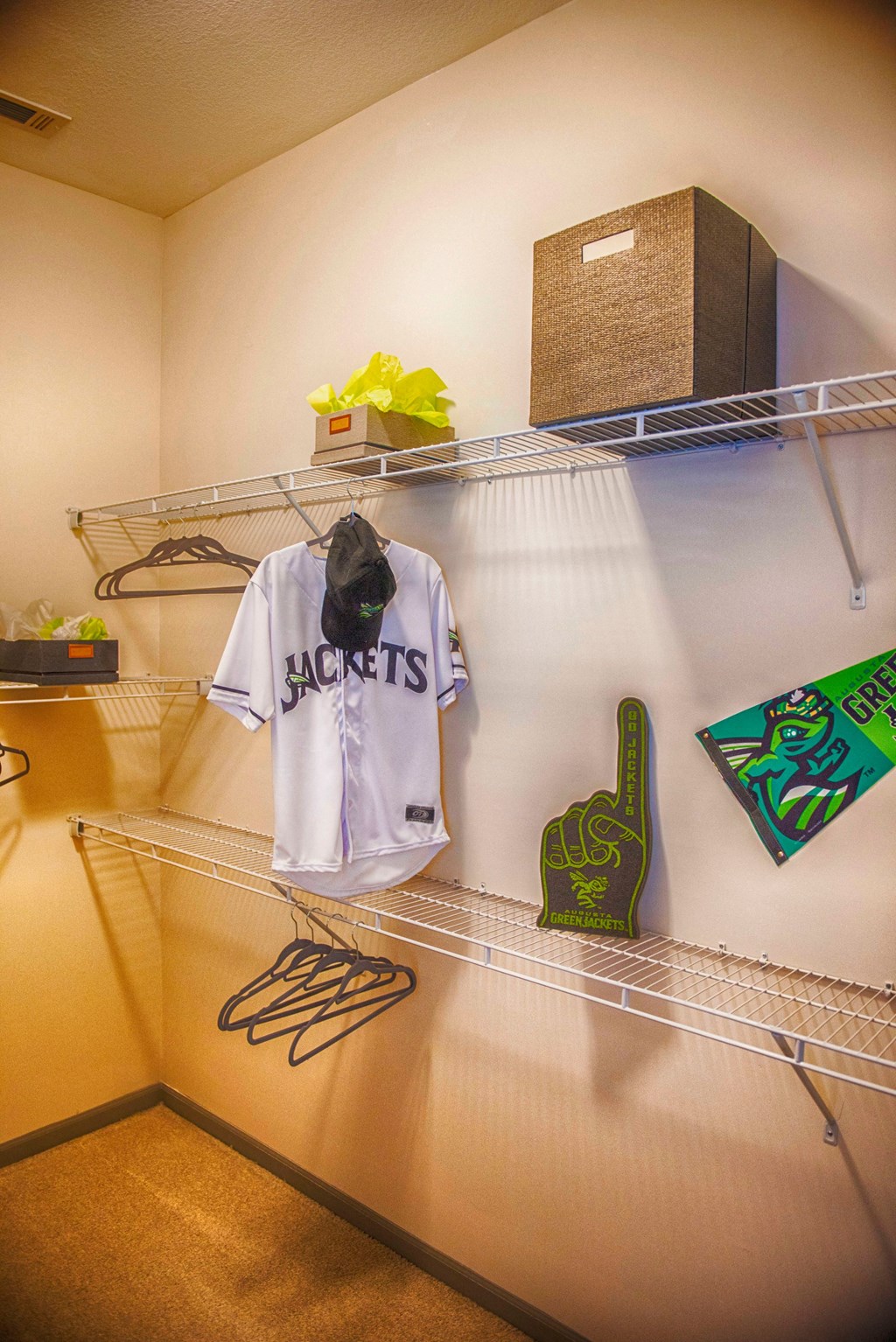 a closet with a rack with a shirt on it and some clothes on it