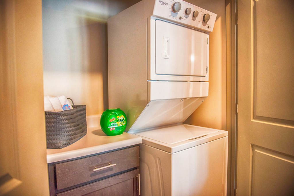 a small laundry room with a washer and dryer and a cabinet with a