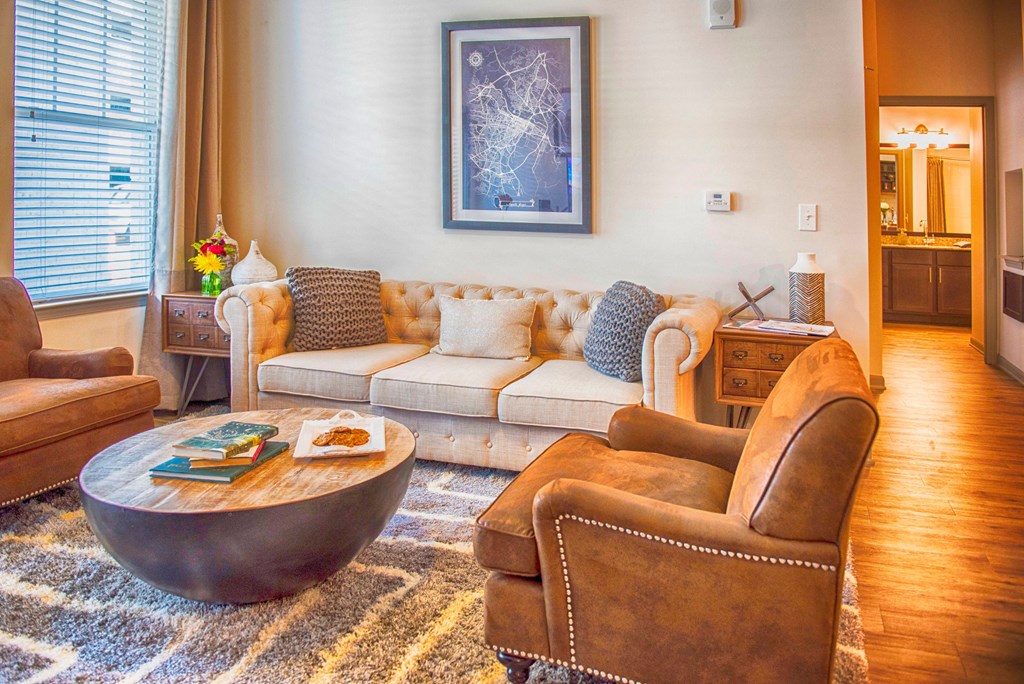 a living room with a couch and chairs and a coffee table