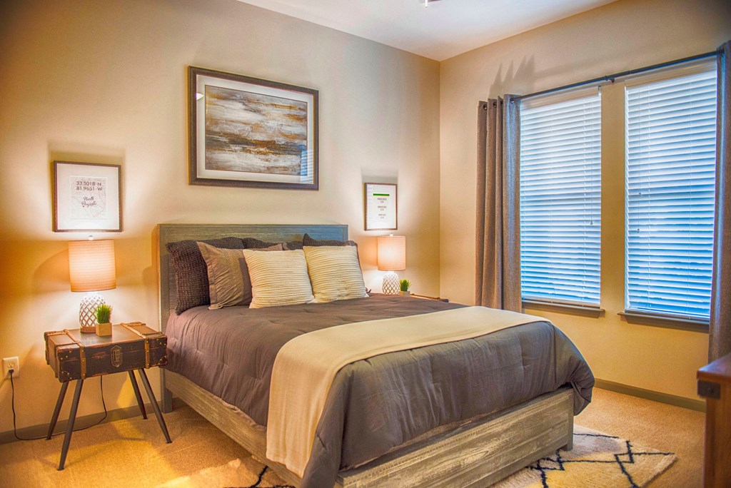 a bedroom with a bed and two windows