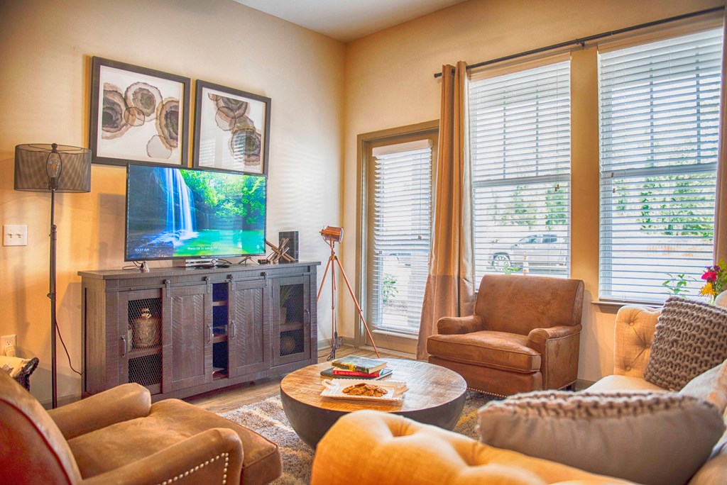 a living room with couches and chairs and a tv