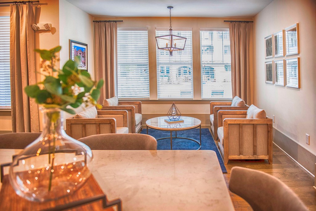 a dining room with a table and chairs and a living room with windows