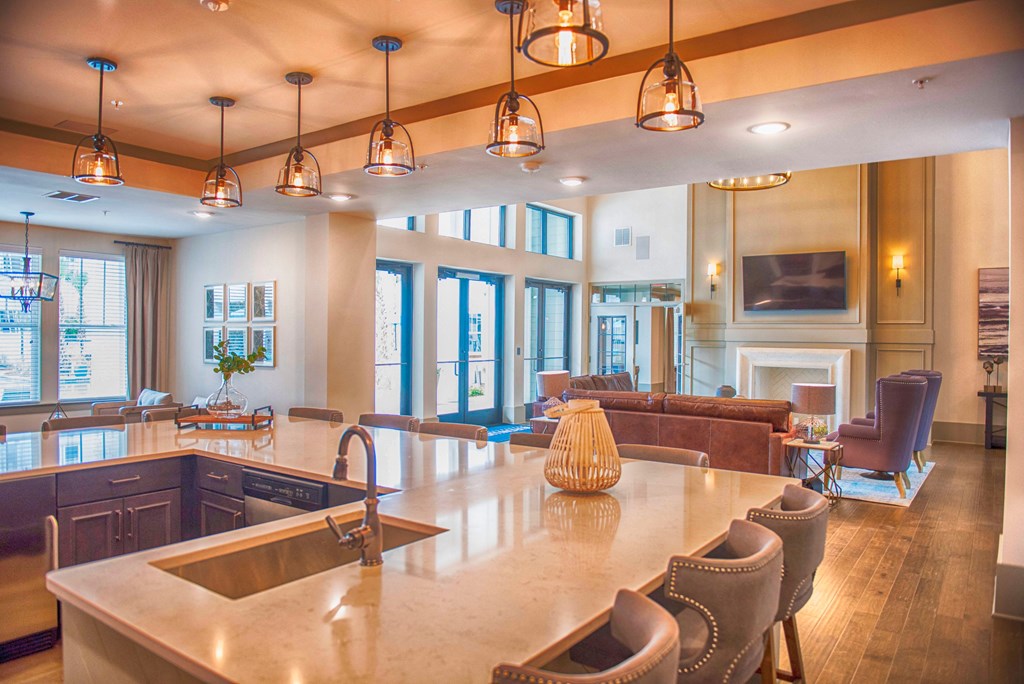 a large kitchen with a bar and a living room with a fireplace