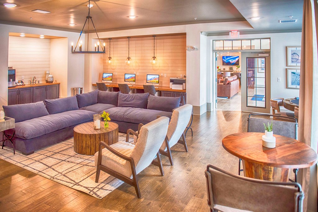 a living room with purple couches and chairs and a dining room with a kitchen