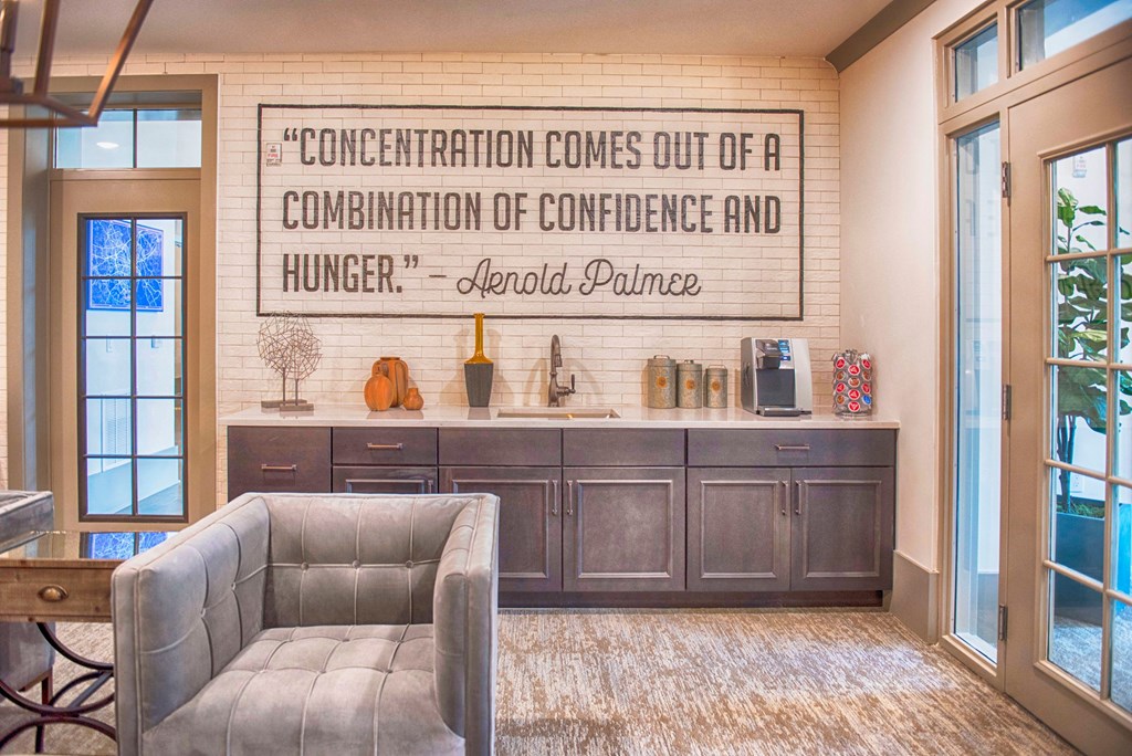 a living room with a couch and a kitchen with a wall quote