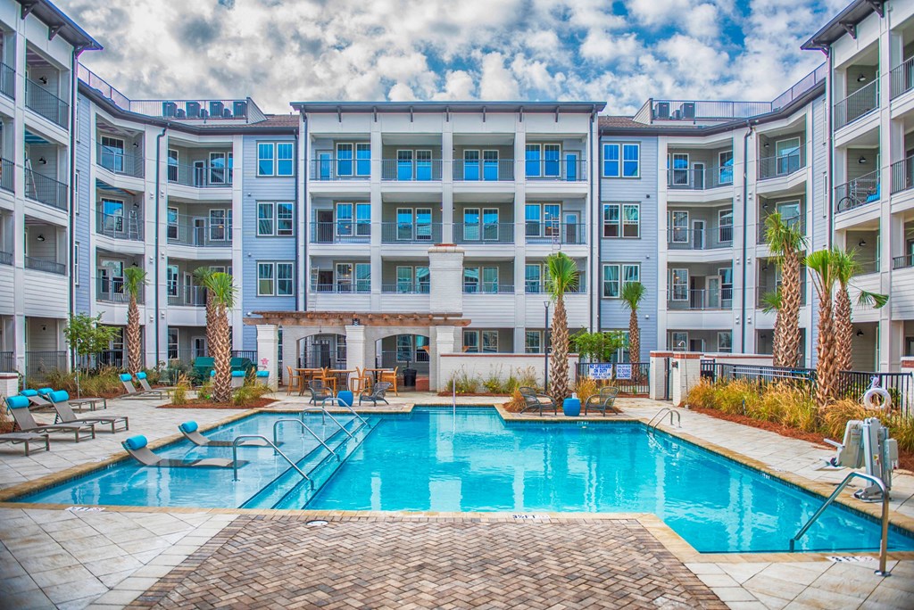 a swimming pool in front of an apartment building with a pool