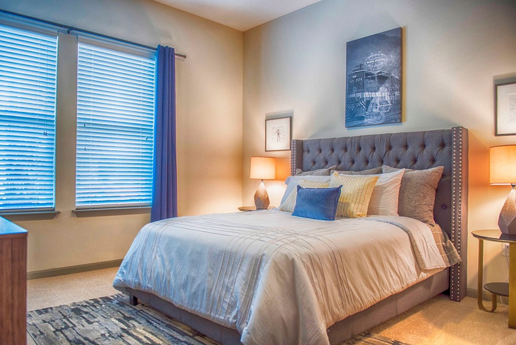 a bedroom with a bed and two windows