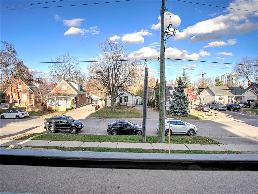 a city street with cars parked in front of houses