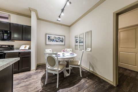A kitchen with a dining table and chairs.