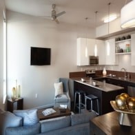 A modern living room with a grey couch and a bar area.