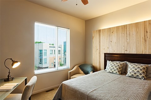 A bedroom with a large bed and a window overlooking a cityscape.