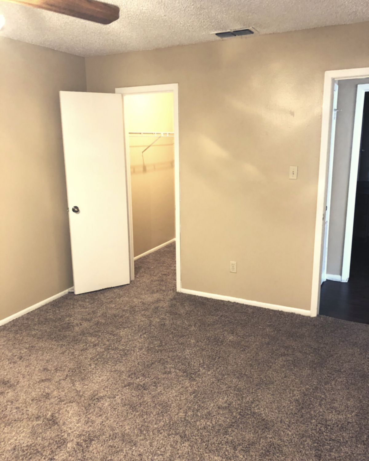 bedroom with neutral brown carpet and white trimming along the wall