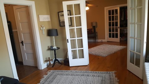 a room with two open doors and a rug on the floor