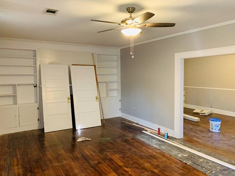 a living room with a hard wood floor and a ceiling fan