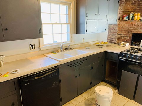 a kitchen with gray cabinets and a sink and a window