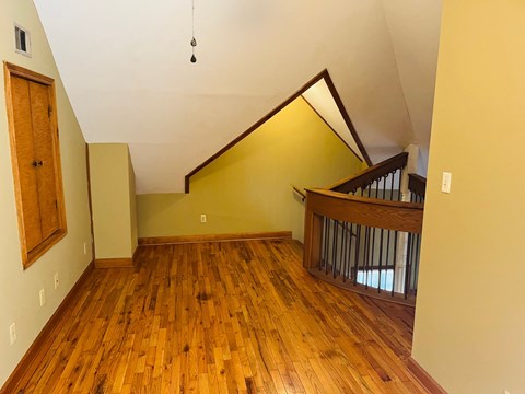 a living room with hard wood floors and a staircase