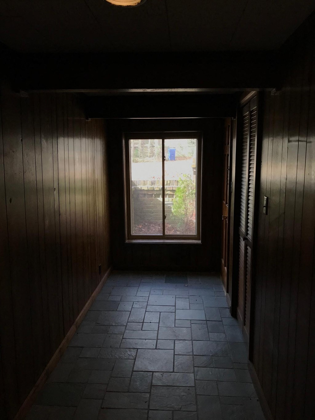 a dark room with a window and a tile floor