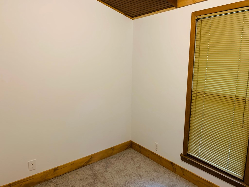 a room with a large window and a carpet