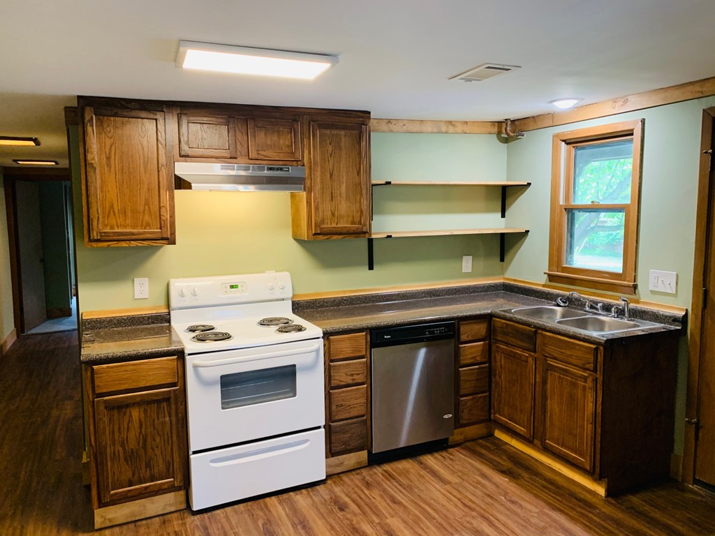 an empty kitchen with a stove and a sink