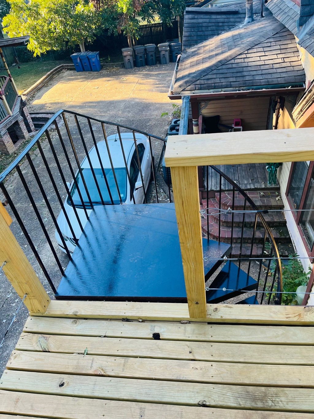 a view of a pool from the top of a wooden deck