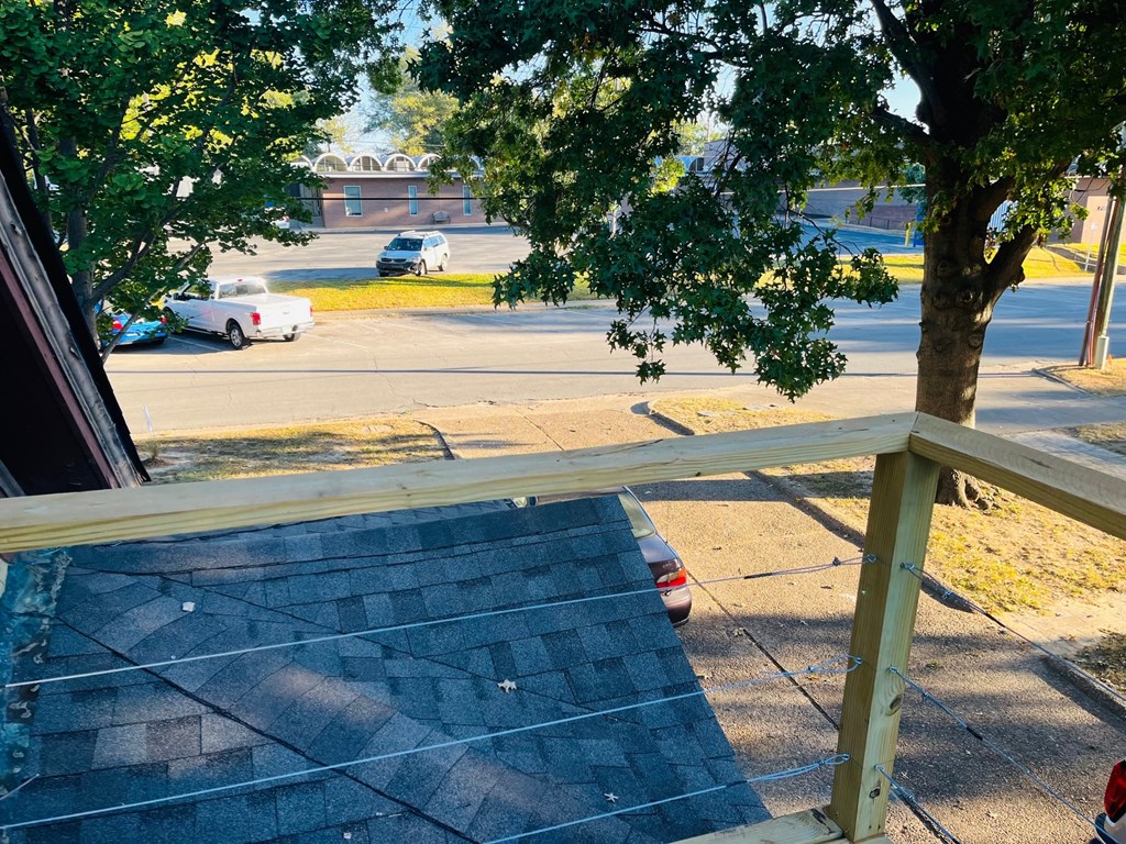 a view of a street from a porch with a tree