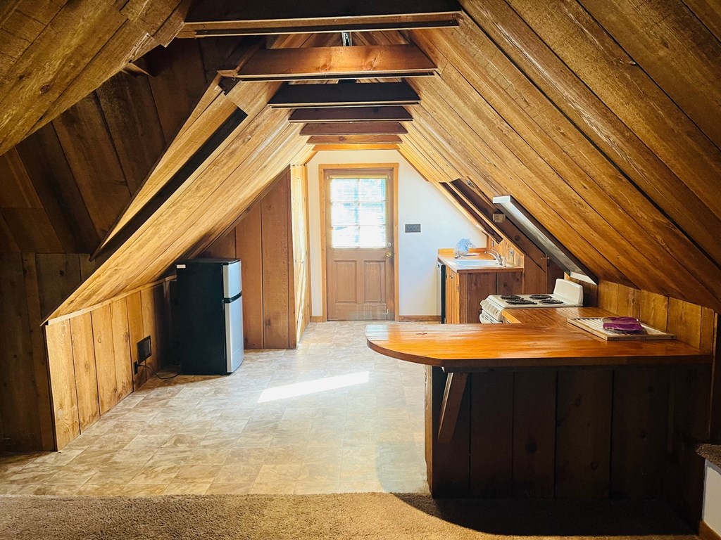 a kitchen in an attic with a door and a table