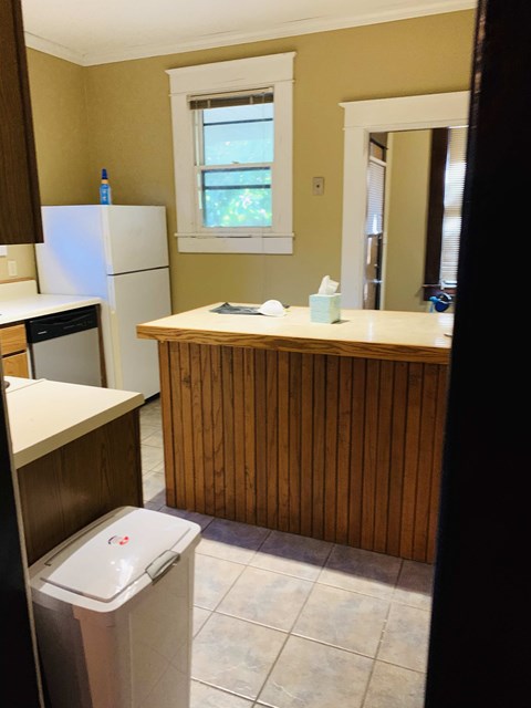 a kitchen with a sink and a trash can in it