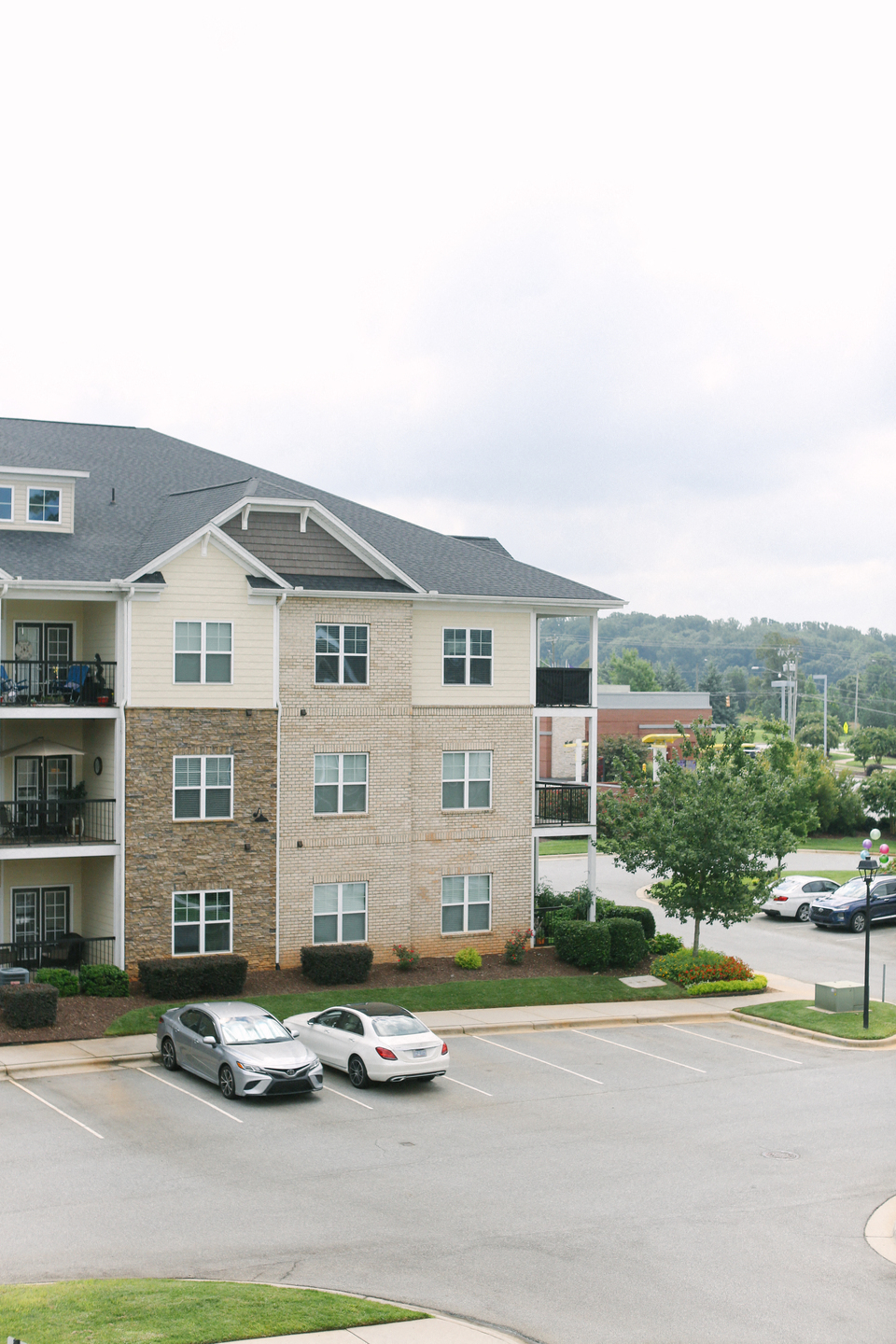 an apartment building with cars parked in a parking lot
