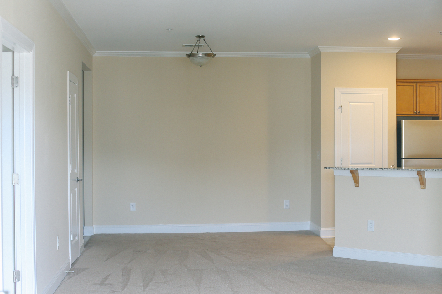 an empty living room with a kitchen in it
