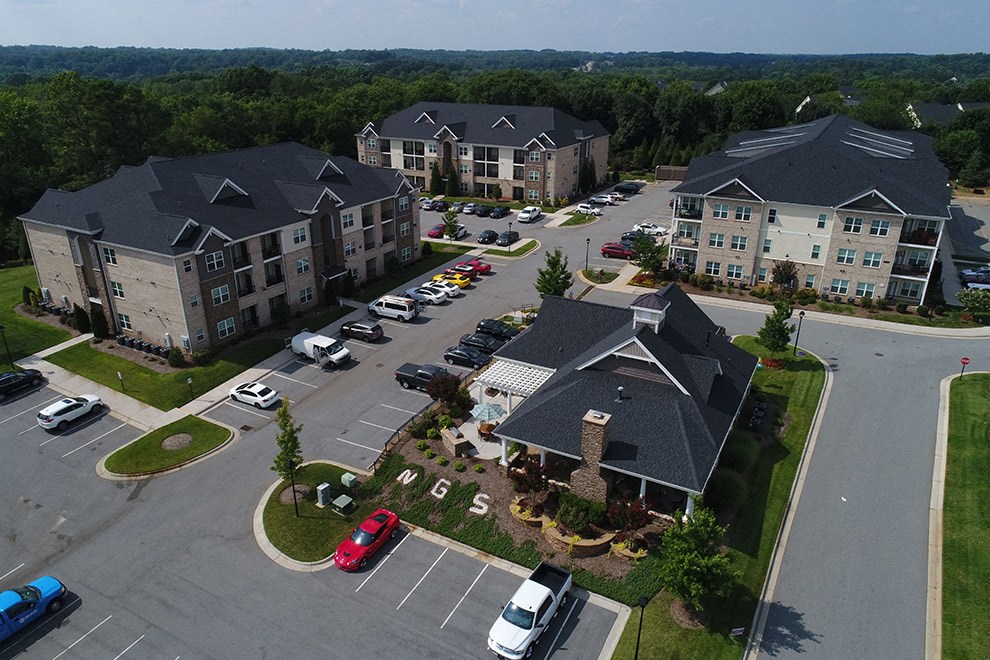 an aerial view of an apartment complex and parking lot