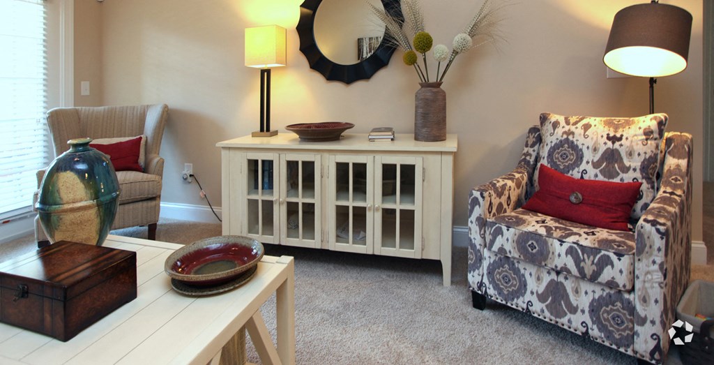 a living room with a chair and a table and a cabinet