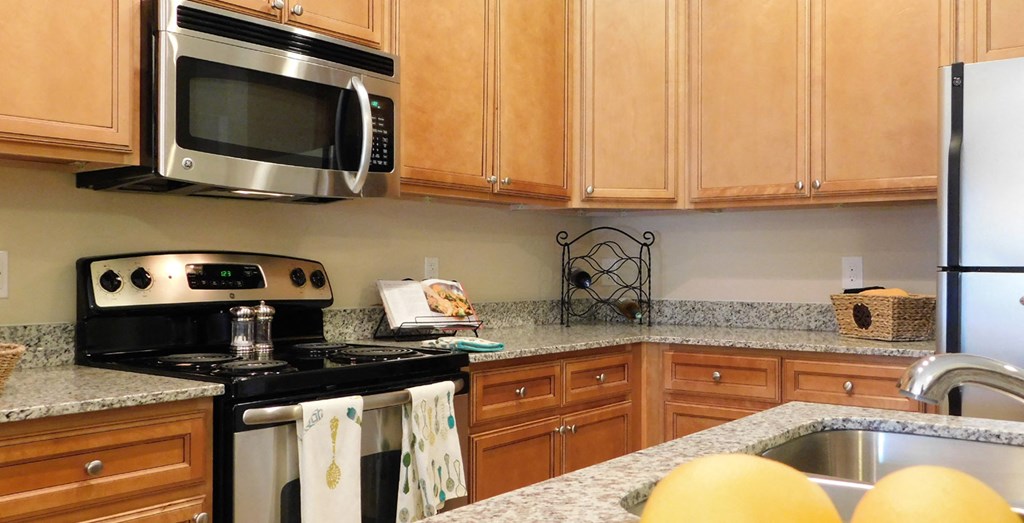 a kitchen with granite counter tops and wooden cabinets