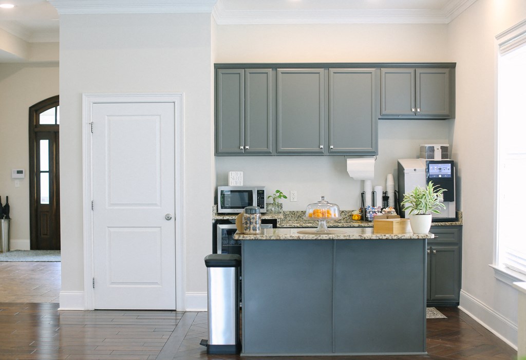 a kitchen with gray cabinets and a counter top and a white door