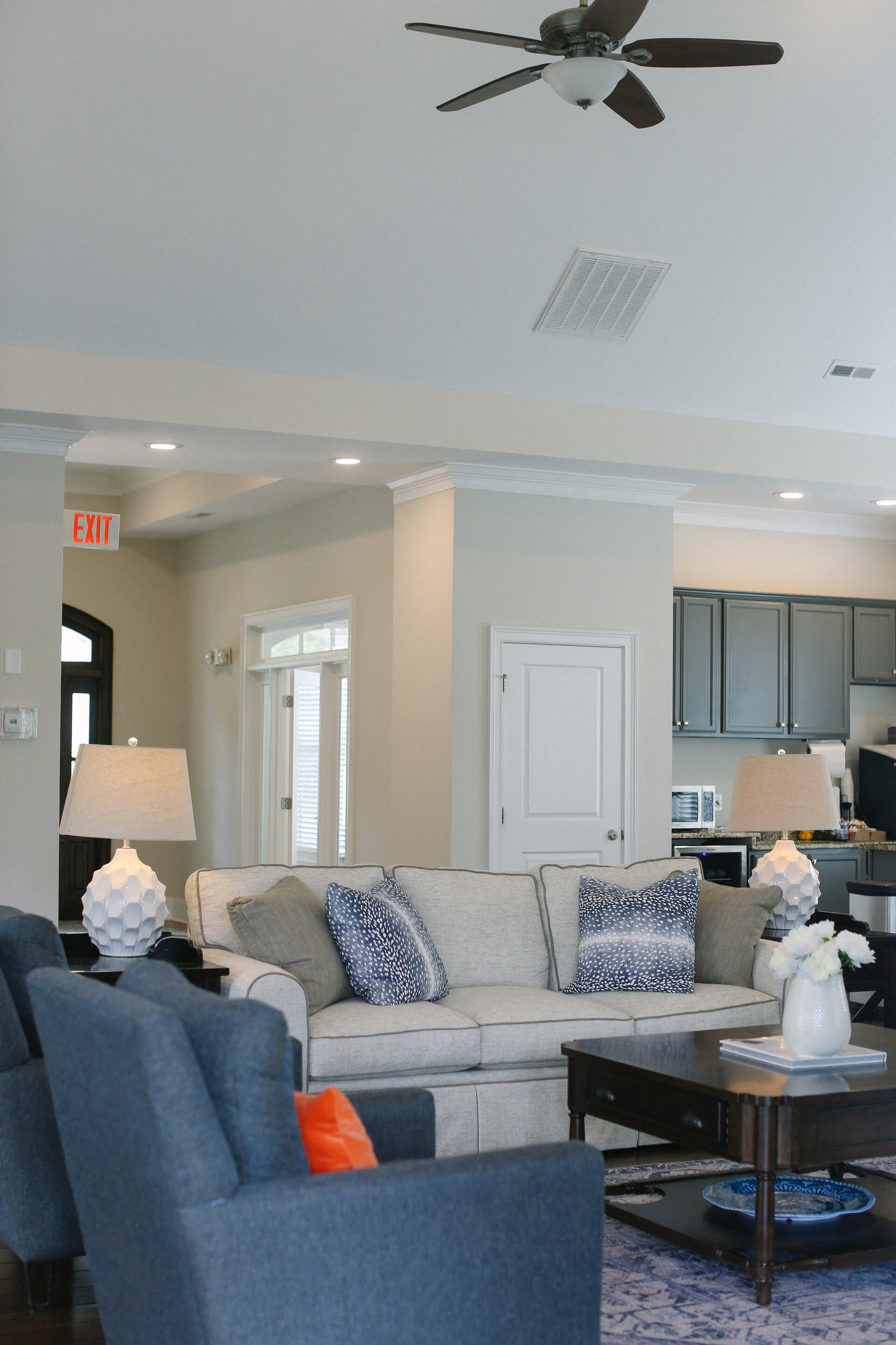 a living room with a couch and chairs and a kitchen